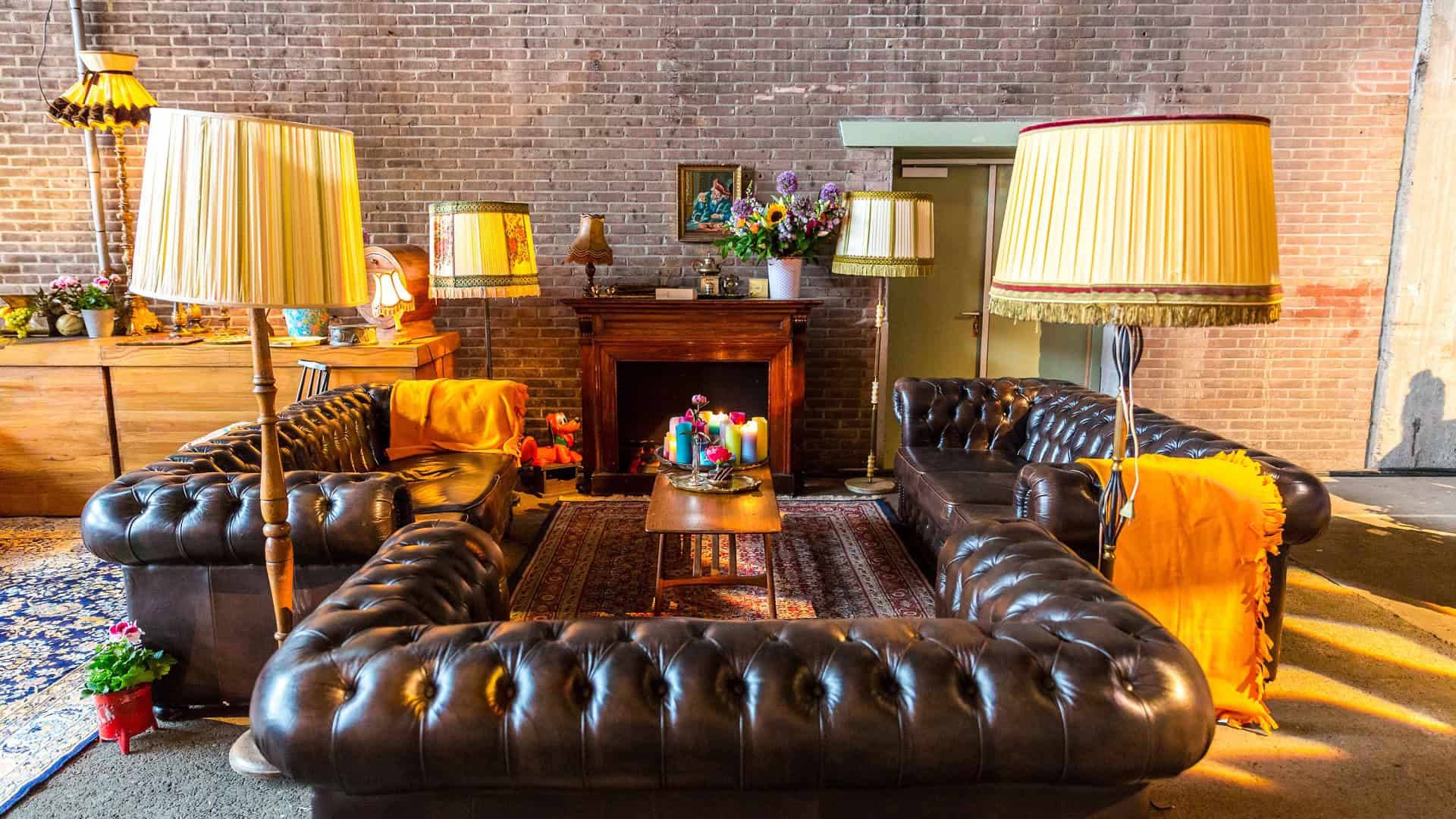 Luxe lounge met leren banken en warme verlichting bij PwC.