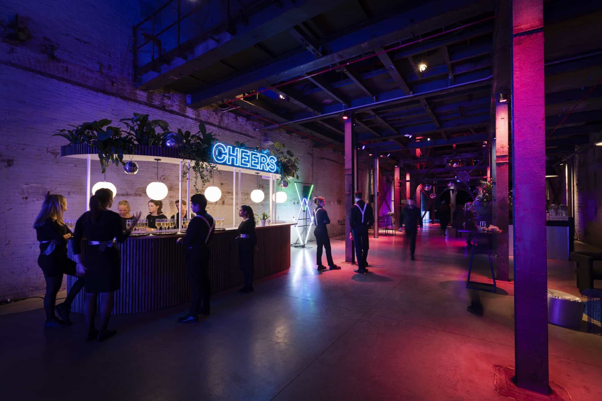 Gezellige bar met kleurrijke verlichting en gasten die genieten.