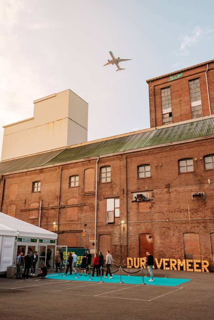 Mensen genieten van een evenement bij Sugar Factory met een vliegtuig in de lucht.