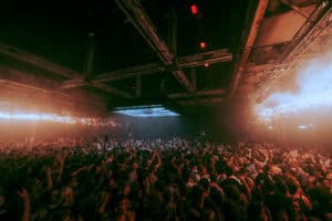 Groots feest bij SugarFactory met dansende menigte en kleurrijk licht.