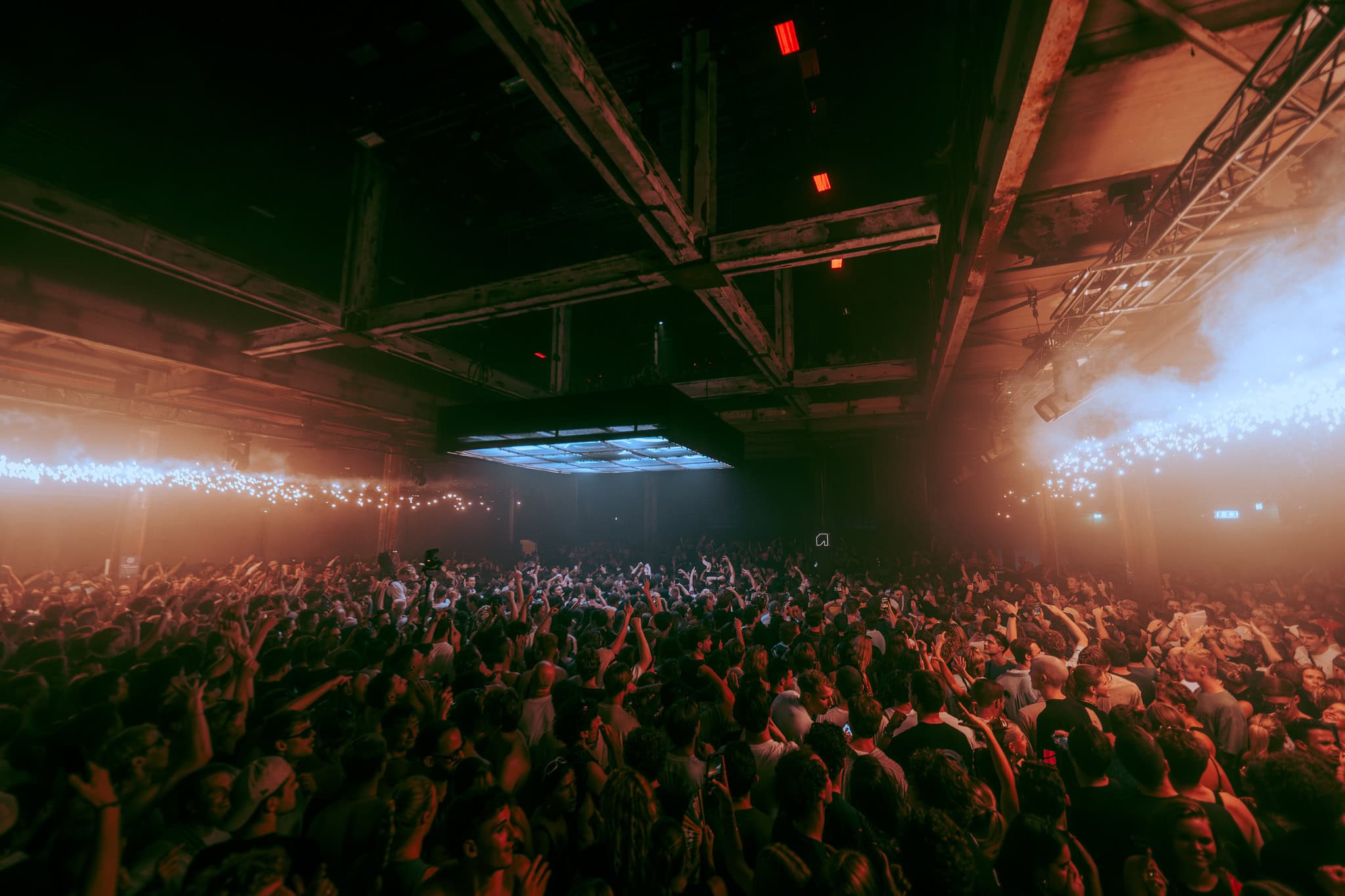 Groots feest bij SugarFactory met dansende menigte en kleurrijk licht.