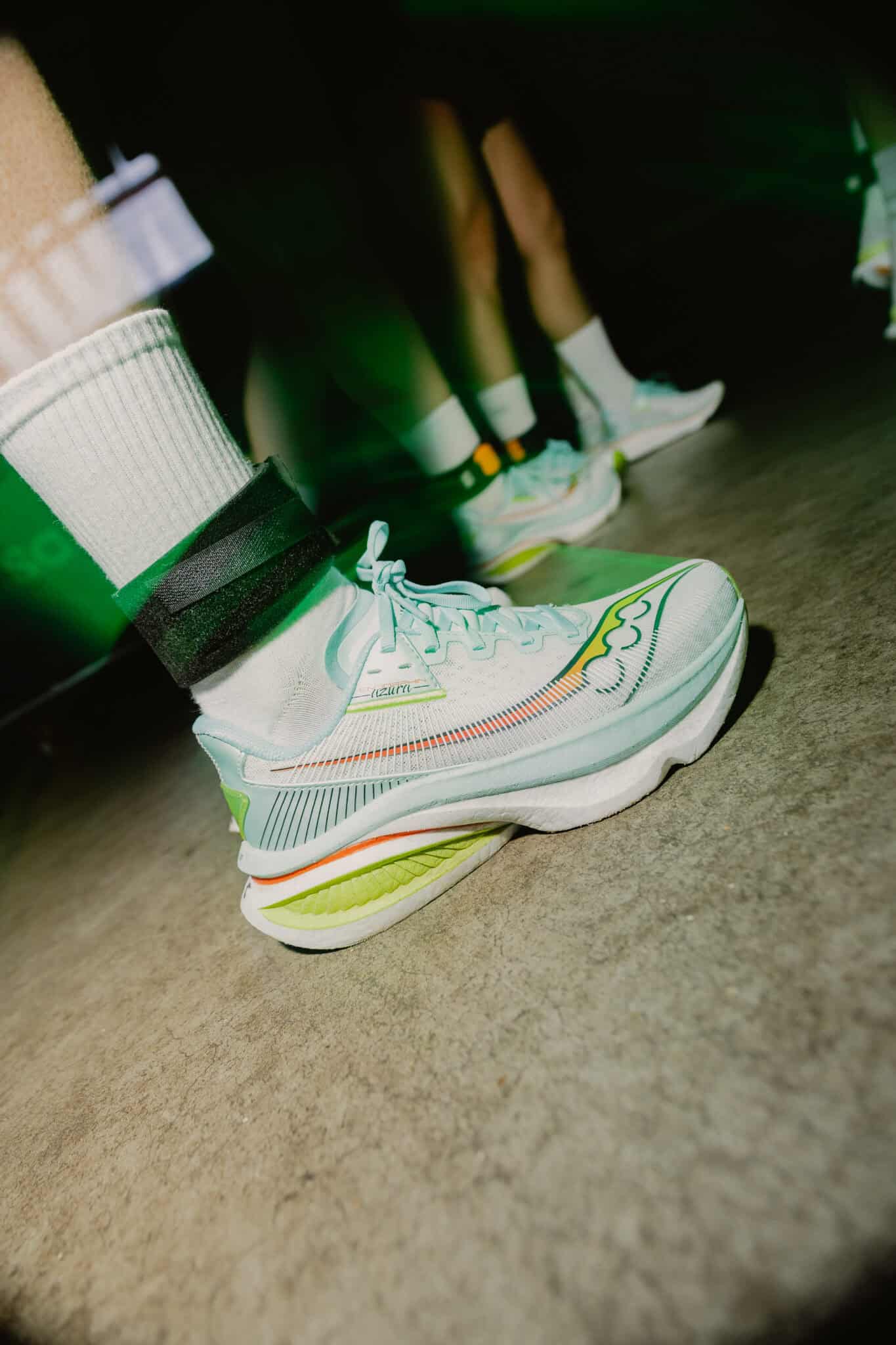 Sportieve witte sneakers met kleurrijke details op de vloer.