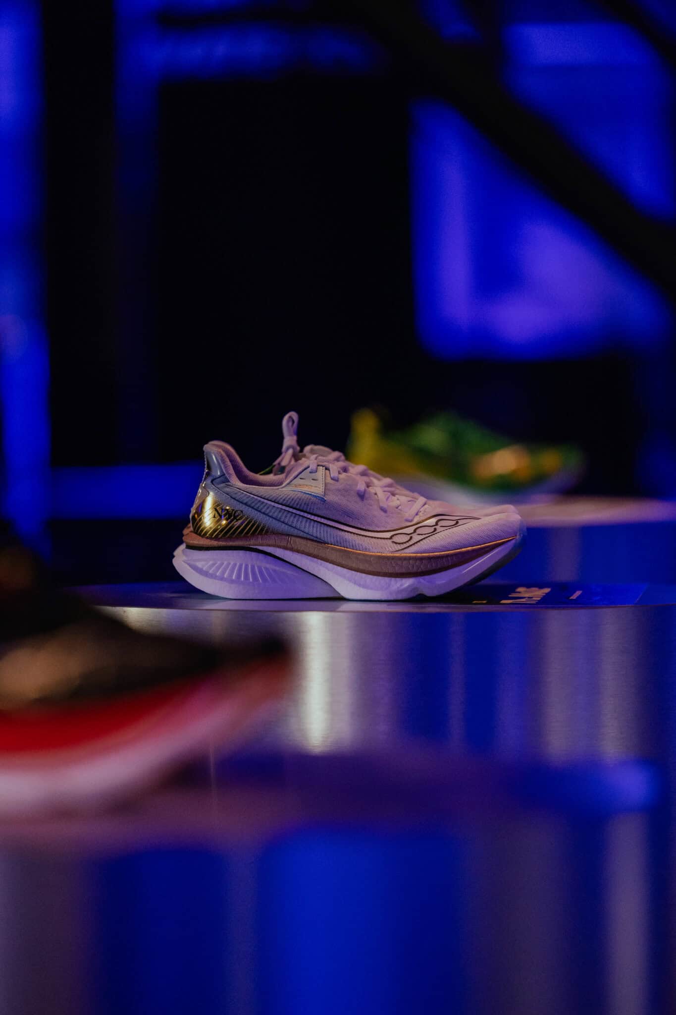 Moderne witte sneaker op display met blauwe achtergrond bij SugarFactory, trendy sneaker mode.