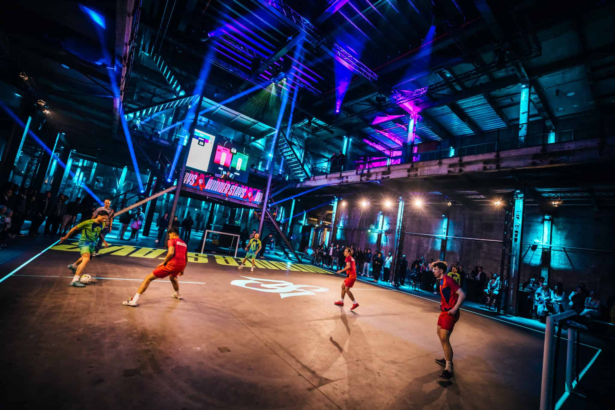 Indoor sporthal met neonverlichting en jongeren die basketballen op een verlichte sportvloer.