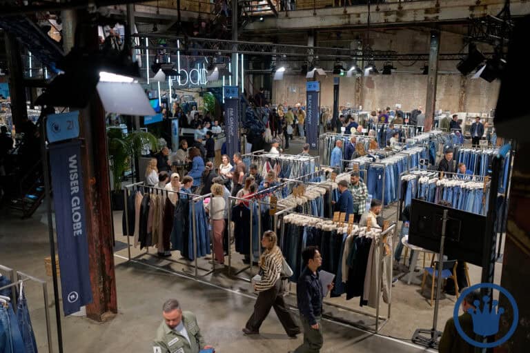 Bezoekers bekijken kledingstalletjes op de KingPins Show in een industrieel gebouw.