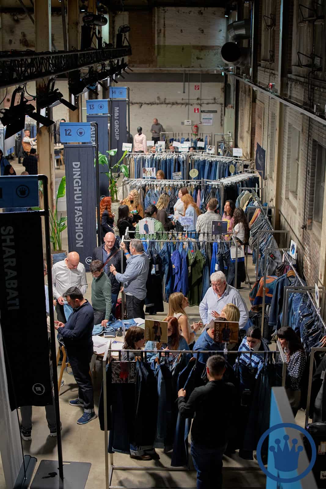 Beurs met kleding en bezoekers tijdens KingPins Show in een industrieel pand.
